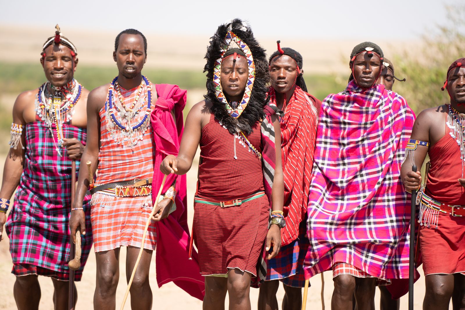 A group of Maasai men walking together across the Kenyan landscape